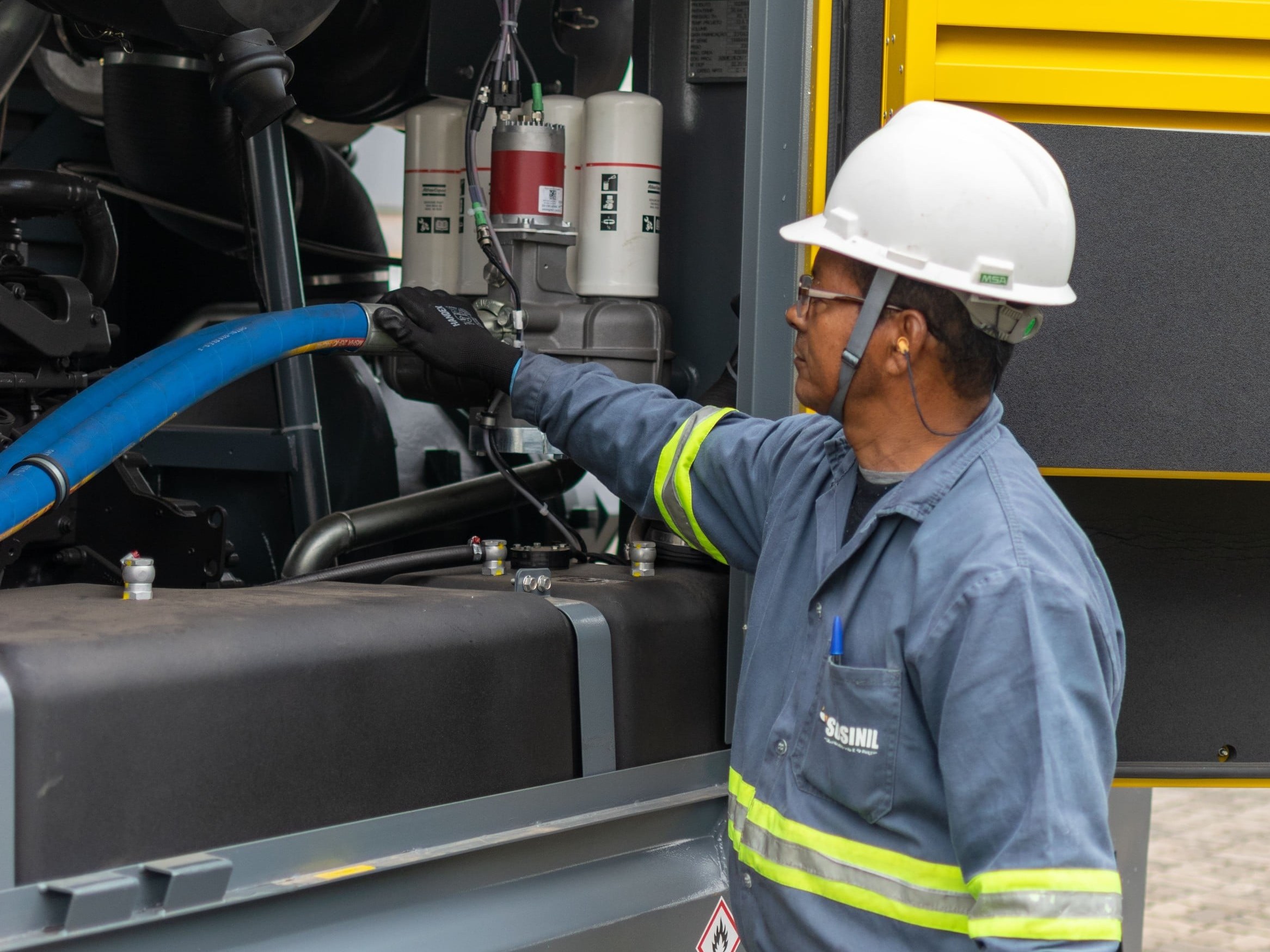 Técnico SOSINIL revisando compressor a diesel pronto para locação